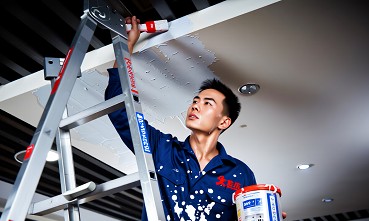 油漆師傅進行細部批土與打磨作業